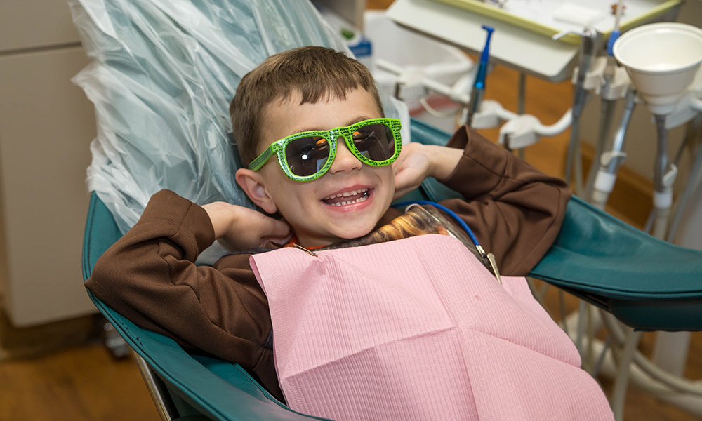 Young patient hanging out on the dental chair with sunglasses on