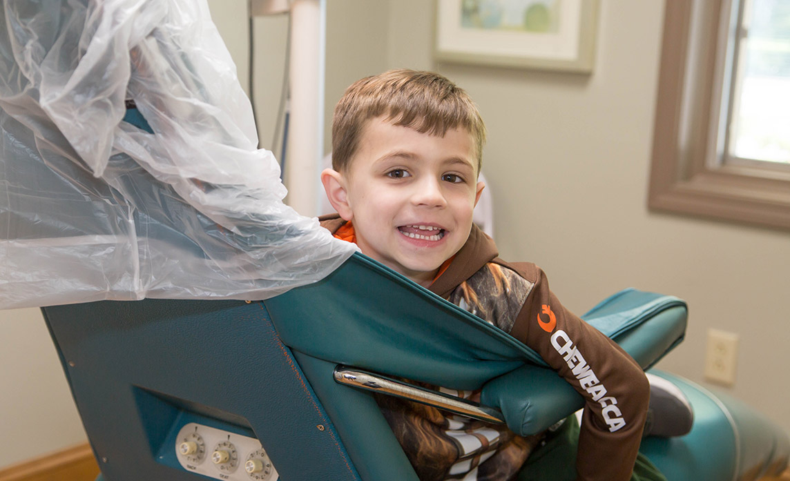 Young patient sitting in an exam chair smiling